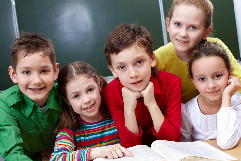 Smiling child hugging his classmates
